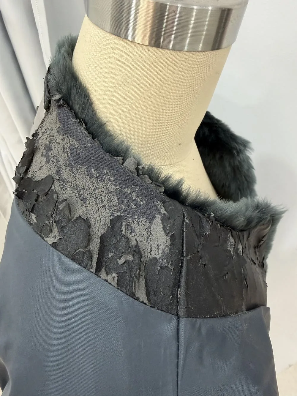 Chaqueta de pelo con polipiel pelado y dañado en el cuello.