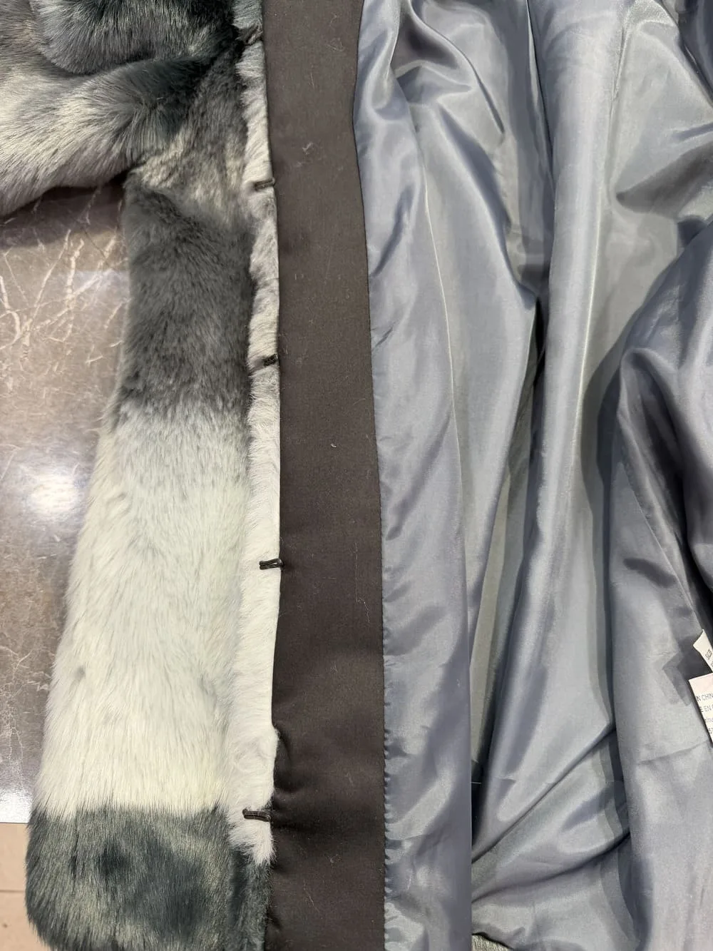 Resultado final de sustitución de polipiel por tela negra en abrigo de pelo.