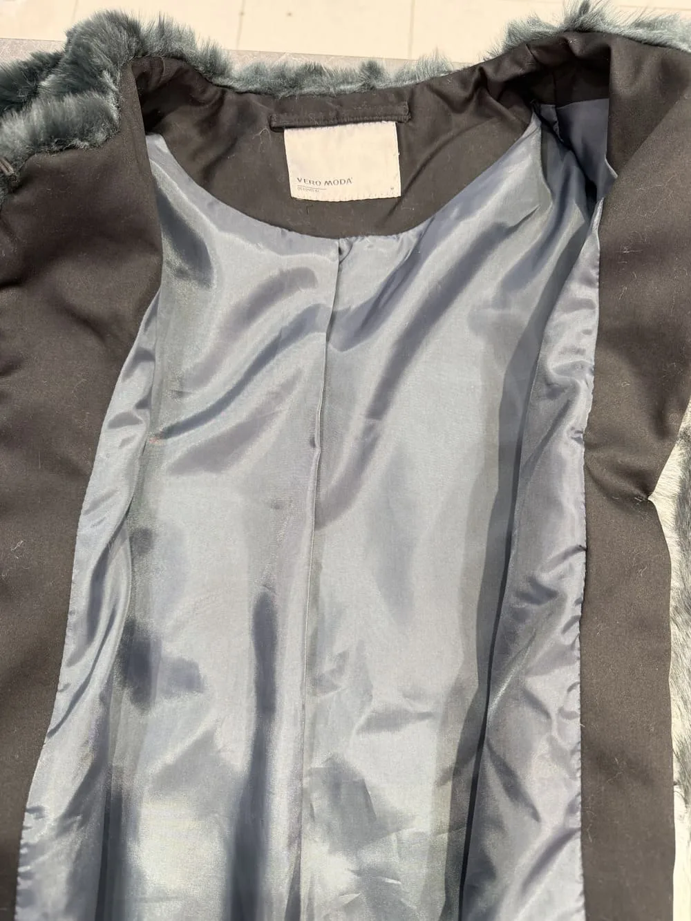 Resultado final de sustitución de polipiel por tela negra en abrigo de pelo.