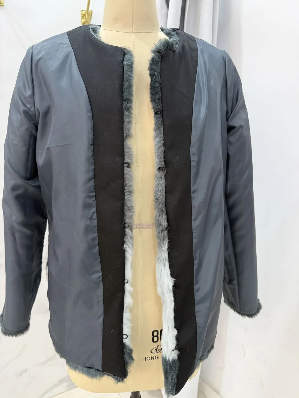 Resultado final de sustitución de polipiel por tela negra en abrigo de pelo.