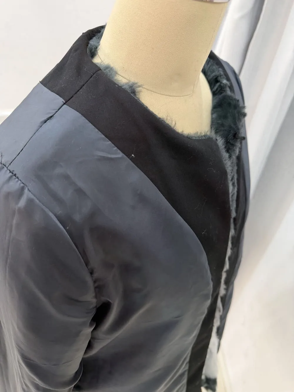 Resultado final de sustitución de polipiel por tela negra en abrigo de pelo.